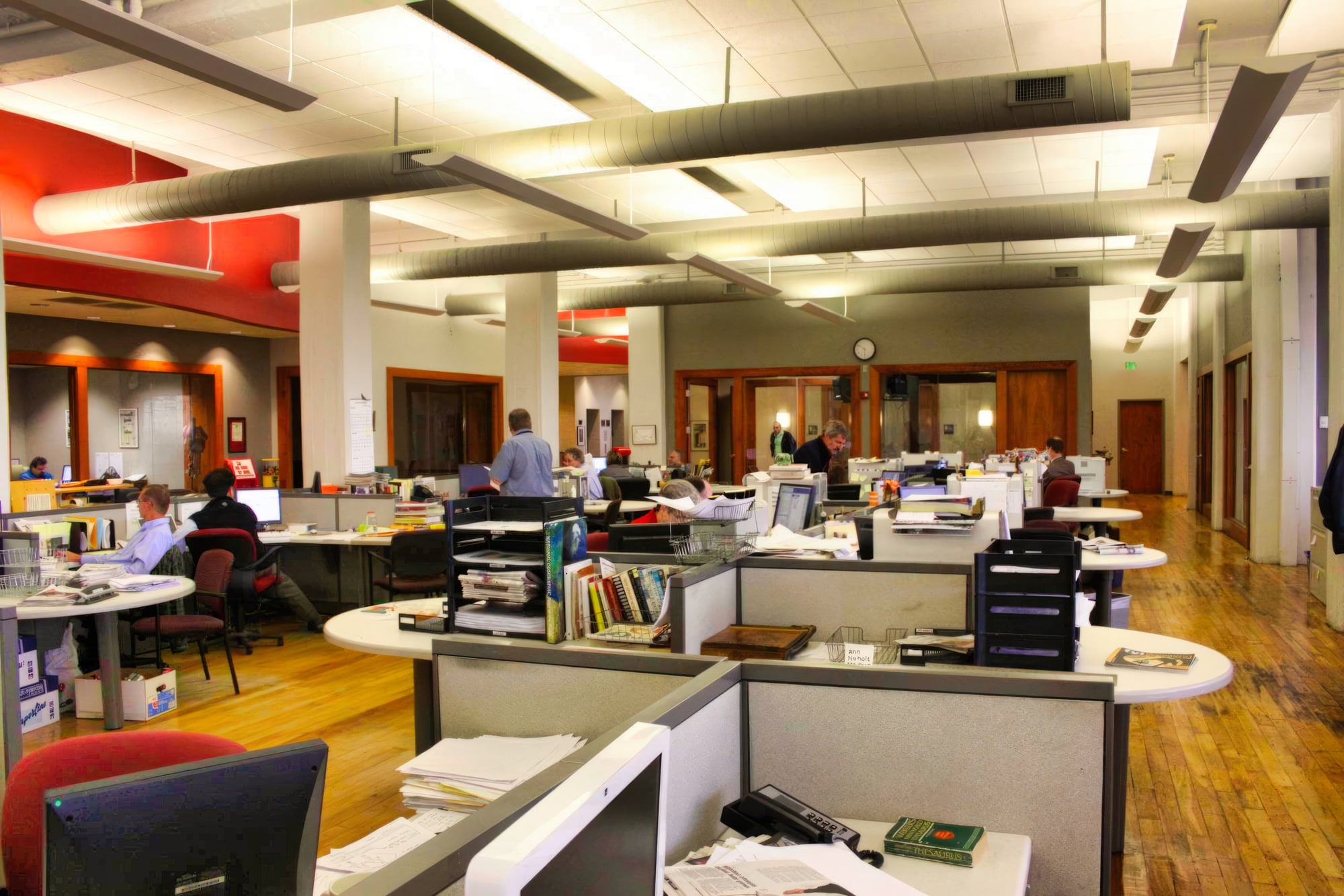 Editors and reporters work in an open newsroom